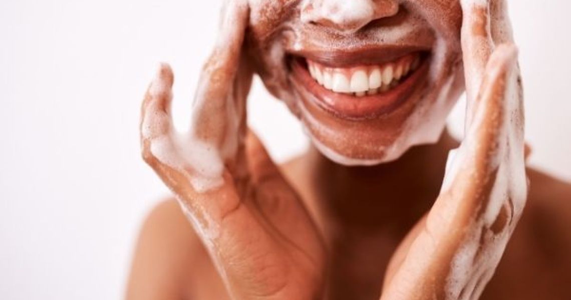 woman smiling washing face